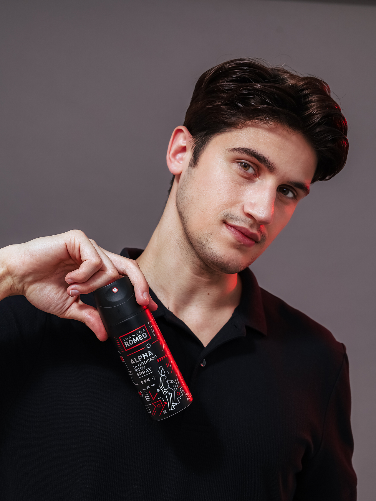 men holding shantos romeo alpha deo body spray in reddish light with gray background studio
